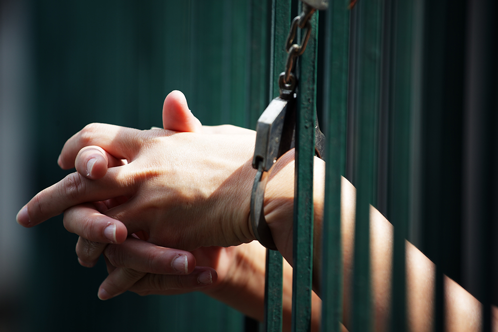 Woman behind prison bars prays