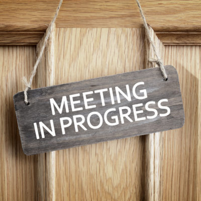 Meeting in progress sign on office door concept for business team staff strategy meeting